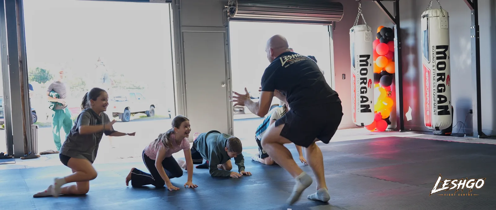 Kids martial arts class training together with a coach at LeshGo Fight Centre in Bulimba