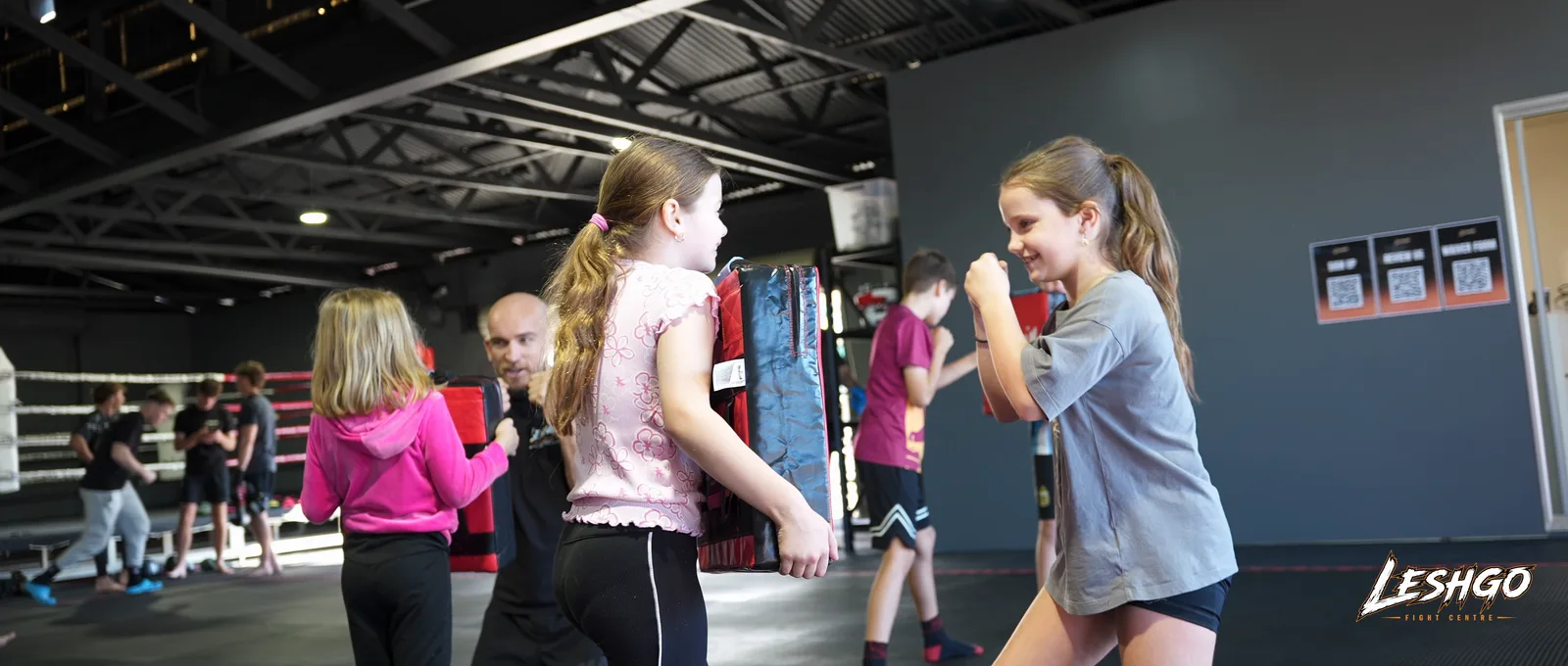 Kids practising MMA striking drills with a coach at LeshGo Fight Centre in Bulimba
